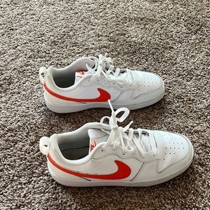 Orange and white Nike shoes